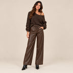 Maglioncino Bardot cioccolato oversize con spalla scoperta abbinato a pantalone effetto pelle, vista frontale