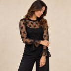 Maglia trasparente nera con fiori in rilievo e maniche lunghe a volant, vista di tre quarti