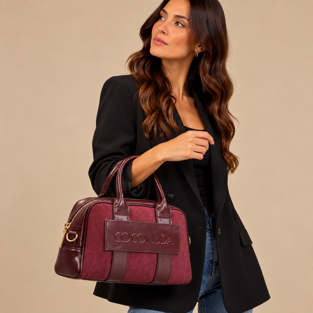 Bauletto Coconuda Borgogna, indossato con blazer nero e tenuto a mano