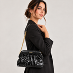 Coconuda Clutch Pouch Nero - indossata a spalla con catena dorata