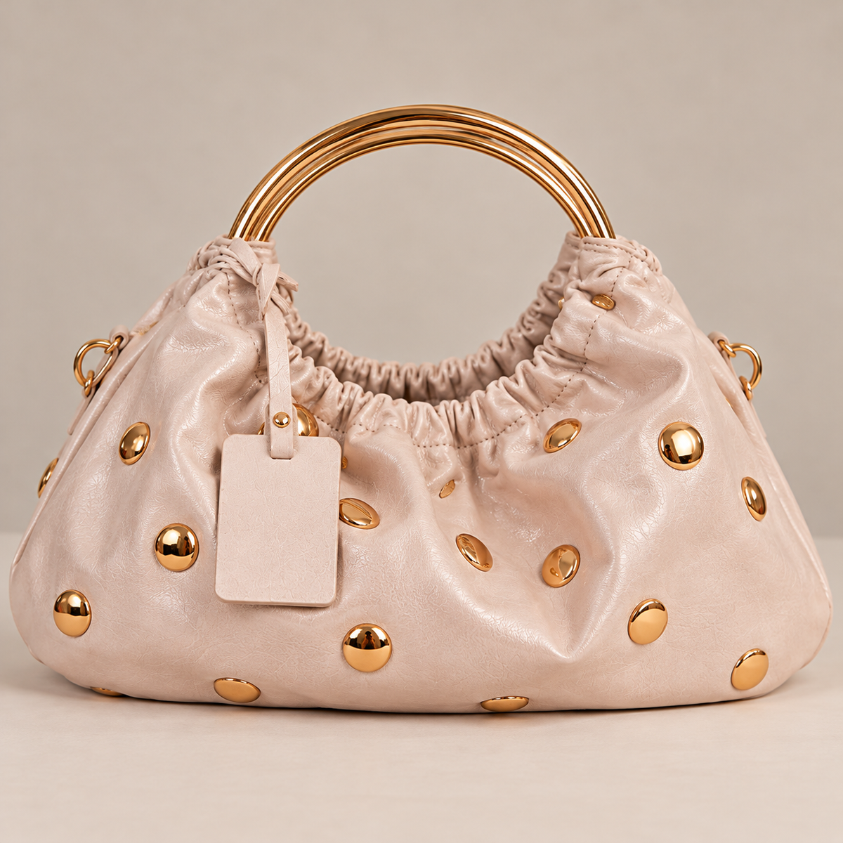 Borsa Adele rosa cipria hobo arricciata con borchie oro e manici ad anello dorati, vista frontale