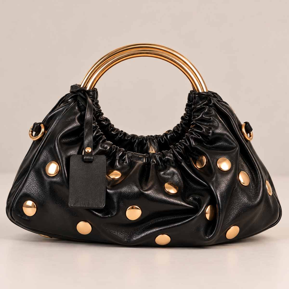 Borsa Adele nera hobo arricciata con borchie oro e manici ad anello dorati, vista frontale